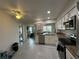 Open-concept kitchen with white cabinets, granite countertops, stainless appliances, and tile flooring at 404 Elder St # 230, Englewood, FL 34223