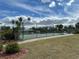Tennis court with green fencing surrounded by trees and landscaping at 404 Elder St # 230, Englewood, FL 34223