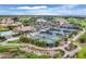Aerial view featuring the community pool, tennis courts, and clubhouse with green spaces at 4301 Whispering Oaks Dr, North Port, FL 34287