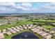 Expansive aerial view of a golf course community, with a lake, lush greenery, and homes at 4301 Whispering Oaks Dr, North Port, FL 34287