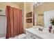 Standard bathroom with a vanity, toilet, and a shower-tub combination with striped curtain at 4301 Whispering Oaks Dr, North Port, FL 34287