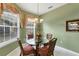 Cozy dining room featuring a glass table, four chairs, bright lighting, and floral curtains at 4301 Whispering Oaks Dr, North Port, FL 34287