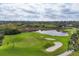 Scenic aerial view of a golf course with lush greenery and sand traps at 4301 Whispering Oaks Dr, North Port, FL 34287