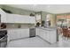 Well-lit kitchen area featuring white cabinets, stainless steel appliances, and tiled flooring at 4301 Whispering Oaks Dr, North Port, FL 34287