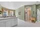 Well-lit kitchen featuring a sink, white cabinetry, and an archway to the dining area at 4301 Whispering Oaks Dr, North Port, FL 34287