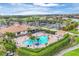 Aerial view of the pool area featuring lounge chairs, shade umbrellas, and lush landscaping at 4301 Whispering Oaks Dr, North Port, FL 34287