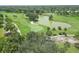 Overhead view of a lush green golf course with a lake, highlighting the scenic landscape and recreational amenities at 454 Cerromar Rd # 174, Venice, FL 34293