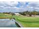 Scenic golf course view with a pond, green, and the clubhouse in the background at 454 Cerromar Rd # 174, Venice, FL 34293