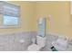 Cozy bathroom with grey tile, white toilet, and a porcelain basin at 456 Matisse S Cir # 456, Nokomis, FL 34275