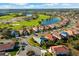 Aerial view of homes in a golf course community surrounded by lush landscaping and blue skies on a clear day at 5106 Pine Shadow Ln, North Port, FL 34287
