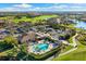 Overhead view of a clubhouse and community pool, tennis courts, parking lot, and golf course at 5106 Pine Shadow Ln, North Port, FL 34287