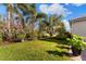 Lush backyard featuring manicured lawn, mature trees, and well-maintained landscaping at 5106 Pine Shadow Ln, North Port, FL 34287