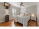 Cozy bedroom with hardwood floors, a ceiling fan, and natural light at 5106 Pine Shadow Ln, North Port, FL 34287