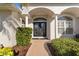 Elegant front entrance featuring a double door with decorative glass, supported by classic white columns at 5106 Pine Shadow Ln, North Port, FL 34287