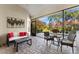 Covered lanai with outdoor seating and views of the lush backyard at 5106 Pine Shadow Ln, North Port, FL 34287