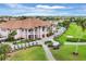 Expansive aerial view of a clubhouse with lush landscaping, golf course, and rows of parked golf carts at 5109 Pine Shadow Ln, North Port, FL 34287