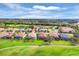 Aerial view of a community with well-maintained lawns, mature trees, and golf course views at 5109 Pine Shadow Ln, North Port, FL 34287