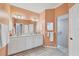 Well-lit bathroom featuring double sinks, tile flooring, and a separate shower area at 5109 Pine Shadow Ln, North Port, FL 34287