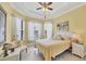 Bright bedroom with yellow walls, tray ceiling, and multiple windows for ample natural light at 5109 Pine Shadow Ln, North Port, FL 34287