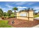 Elegant Pine Meadows community sign with lush landscaping and beautiful blue skies at 5109 Pine Shadow Ln, North Port, FL 34287