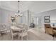 Dining area with seating for six, modern light fixture, and easy access to other rooms at 5109 Pine Shadow Ln, North Port, FL 34287