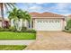 Charming single-story home featuring a terra cotta tile roof, two-car garage, and lush tropical landscaping at 5109 Pine Shadow Ln, North Port, FL 34287