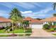 Beautiful single-story home with a terra cotta roof, palm trees, and a patterned driveway at 5109 Pine Shadow Ln, North Port, FL 34287