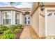 Inviting front entrance with double doors, manicured landscaping, and a patterned walkway leading to the home at 5109 Pine Shadow Ln, North Port, FL 34287