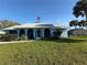 Charming blue home with arched porch, well-kept lawn, and mature palm trees create a cozy curb appeal at 519 Bellaire Dr, Venice, FL 34293