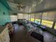 Relaxing sun room enclosed with screened windows and a ceiling fan at 519 Bellaire Dr, Venice, FL 34293