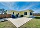 A vibrant yellow home with a concrete patio and a well-maintained, spacious backyard at 551 Sheridan Dr, Venice, FL 34293