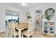 Bright dining room with a wooden table, white chairs, and a view into a sunlit living area at 551 Sheridan Dr, Venice, FL 34293