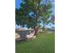 Backyard features a comfy outdoor sofa next to a mature shady tree for relaxation at 605 Cumberland Rd, Venice, FL 34293