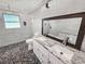 Modern bathroom featuring a double sink vanity, granite countertop, walk-in shower, and unique pebble flooring at 605 Cumberland Rd, Venice, FL 34293