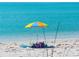 Beach with a colorful umbrella and people enjoying the view of the ocean at 605 Cumberland Rd, Venice, FL 34293