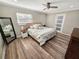 Inviting bedroom with modern ceiling fan, wood-look flooring, and natural light at 605 Cumberland Rd, Venice, FL 34293