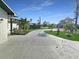 Long driveway with an elegant water feature, framed by palm trees and lush landscaping at 605 Cumberland Rd, Venice, FL 34293