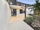 The entrance to a home with decorative landscaping and a tile walkway at 605 Cumberland Rd, Venice, FL 34293