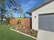 Fresh landscaping enhances the curb appeal of this home, showcasing the gray garage door and stone accents at 605 Cumberland Rd, Venice, FL 34293