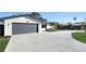 A house with a freshly paved driveway and a two-car garage surrounded by manicured landscaping at 605 Cumberland Rd, Venice, FL 34293