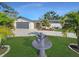 Charming home with manicured lawn and elegant fountain, complemented by lush palm trees at 605 Cumberland Rd, Venice, FL 34293