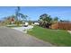Beautiful single-story home with a well-manicured front yard, mature trees, and a circular driveway at 605 Cumberland Rd, Venice, FL 34293