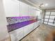 Organized garage with custom white cabinets, sleek countertops, and a stylish backsplash at 605 Cumberland Rd, Venice, FL 34293
