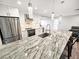 Modern kitchen with stainless steel appliances, white cabinets, a granite island, and pendant lights at 605 Cumberland Rd, Venice, FL 34293
