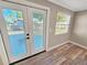 Living room showing sliding doors with wood-look floor at 605 Cumberland Rd, Venice, FL 34293
