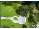 Aerial view of the property featuring a long driveway, lush green lawn, a pond and mature trees at 651 Percheron Cir, Nokomis, FL 34275