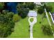 Aerial view of property with a long driveway, lush green lawn, trees, and nearby pond at 651 Percheron Cir, Nokomis, FL 34275