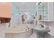Bathroom with white tile, a large tub, and a pedestal sink at 651 Percheron Cir, Nokomis, FL 34275