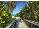 Beach access framed by lush foliage with the turquoise ocean visible in the distance at 651 Percheron Cir, Nokomis, FL 34275