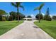 Charming home featuring a circular driveway, manicured lawn, and lush landscaping at 651 Percheron Cir, Nokomis, FL 34275